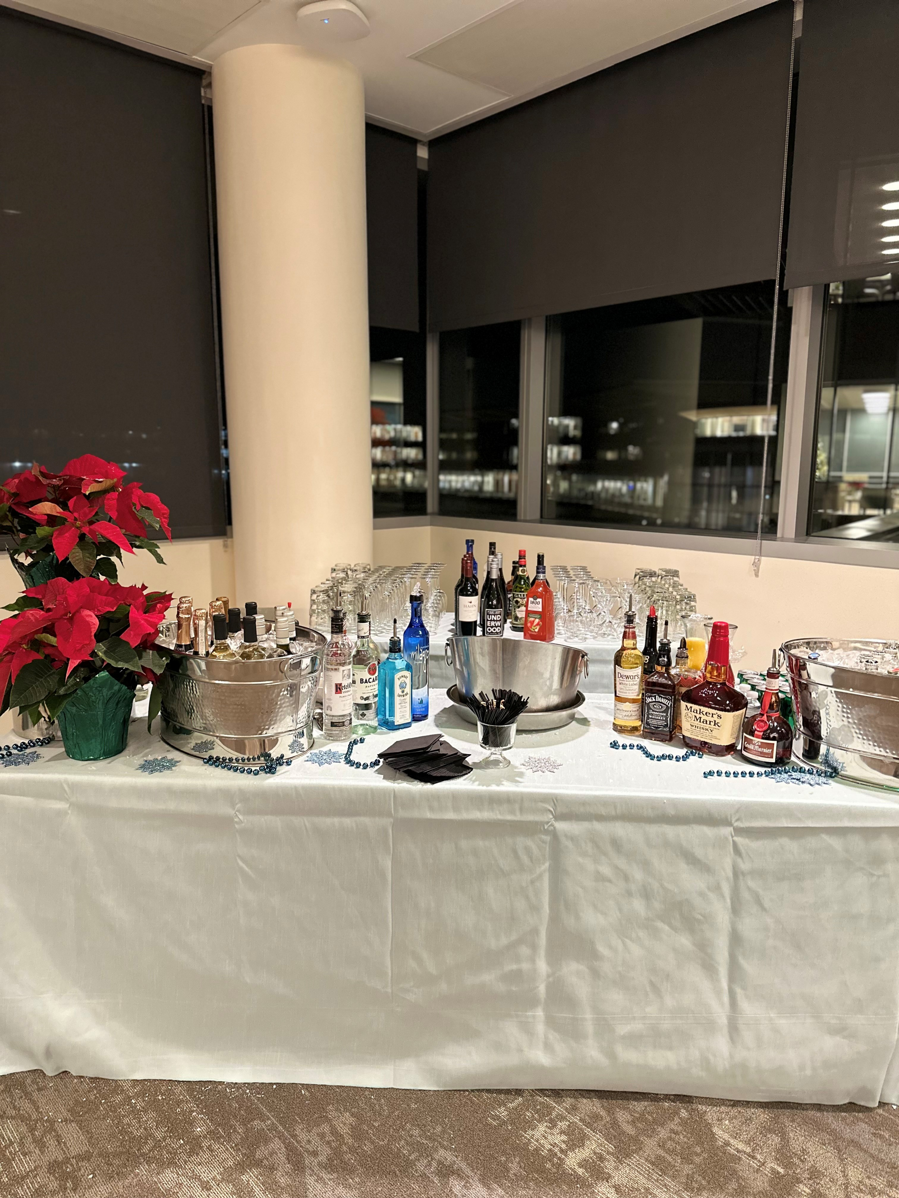 Bar setup with drinks on white table.