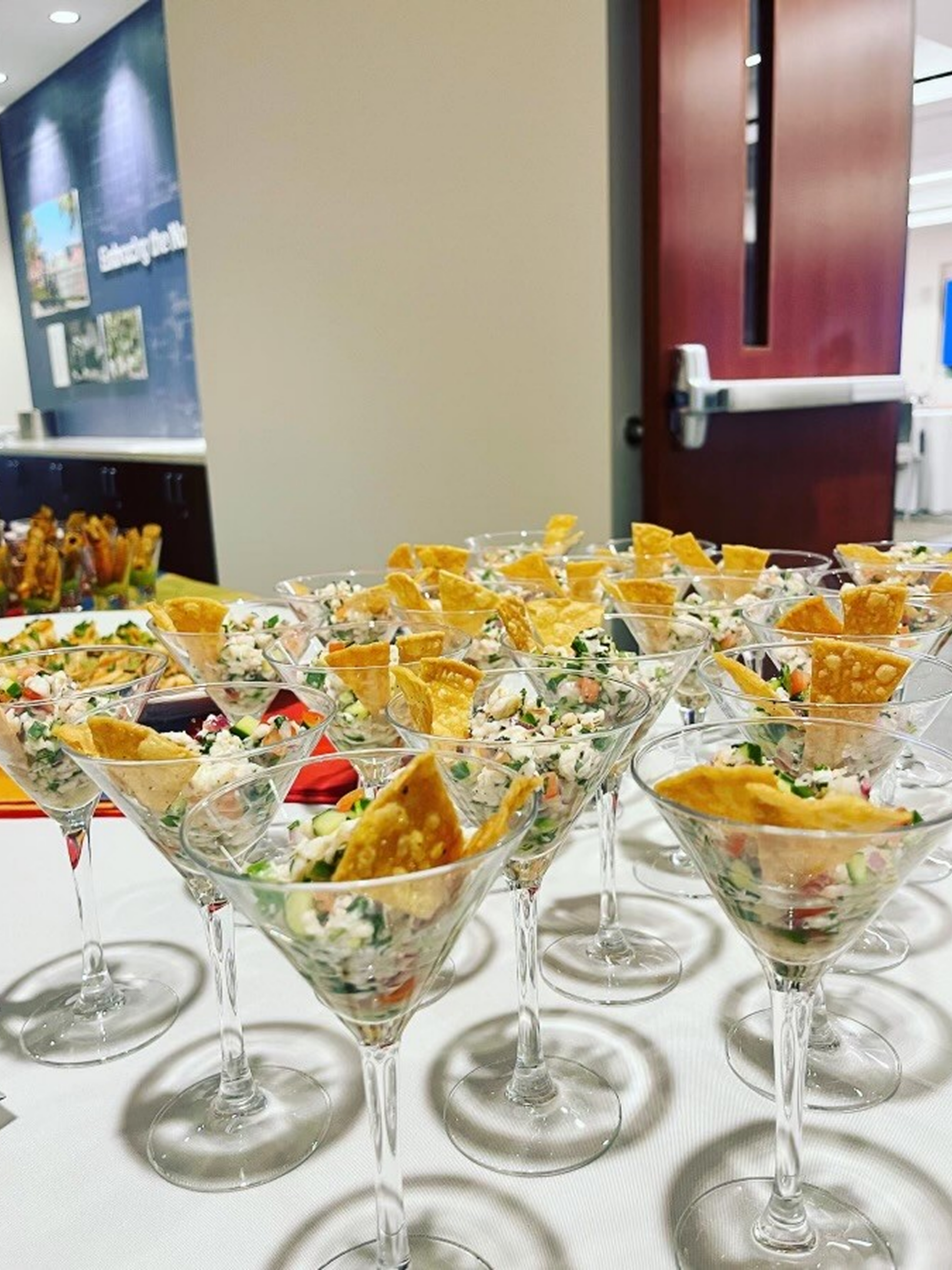 Martini glasses filled with appetizer and chips.
