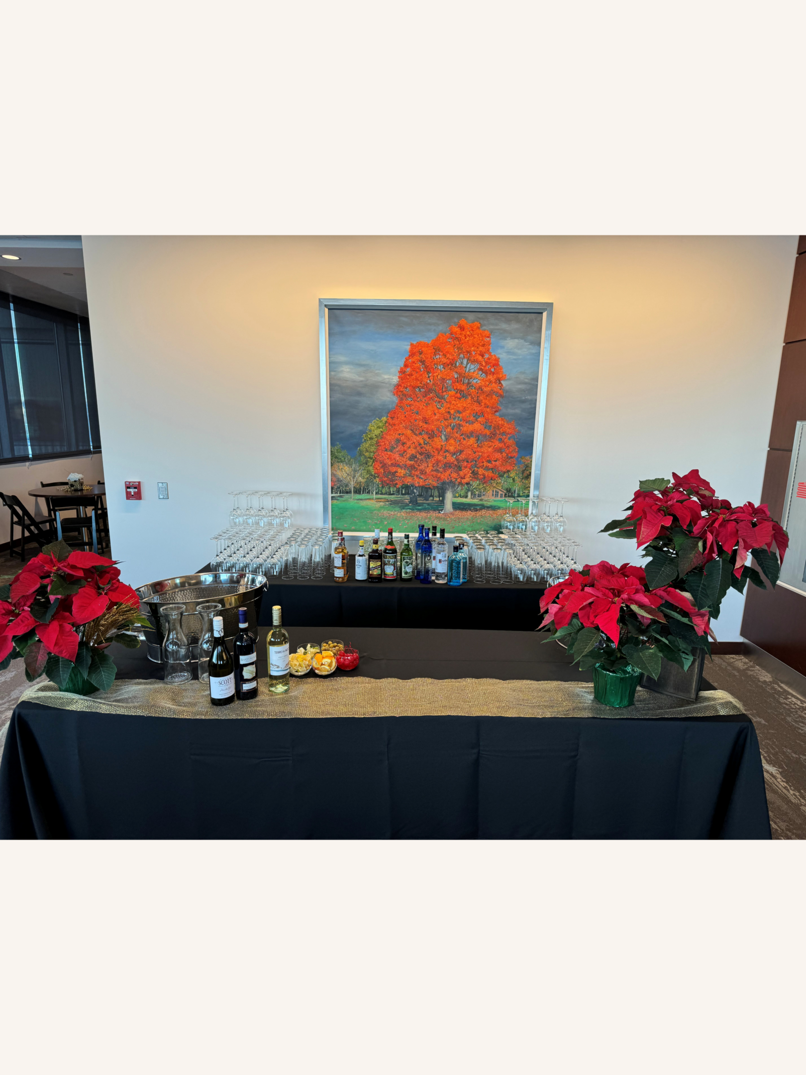 Bar setup with poinsettias and autumn painting.