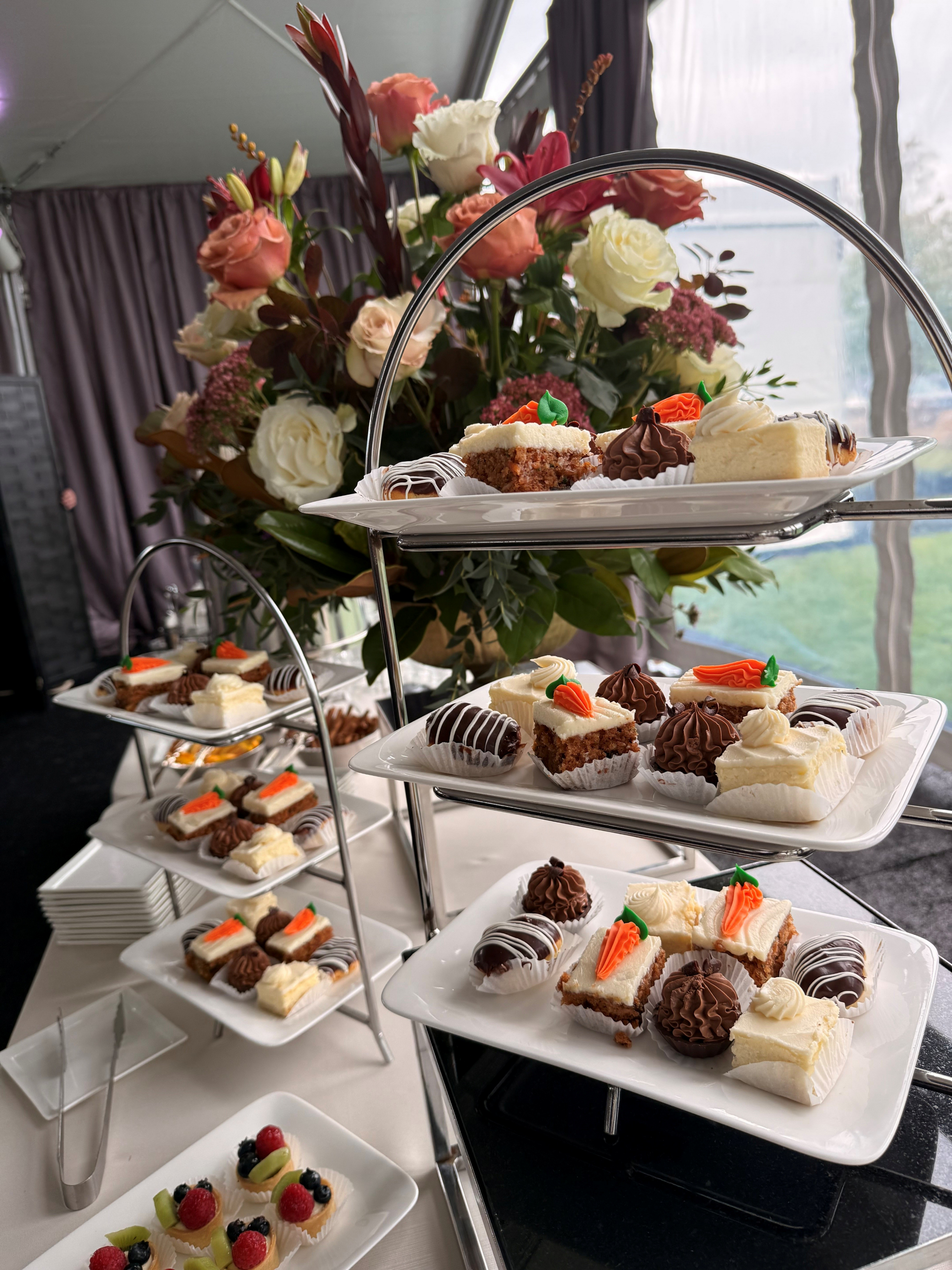 Dessert trays with assorted pastries and flowers.
